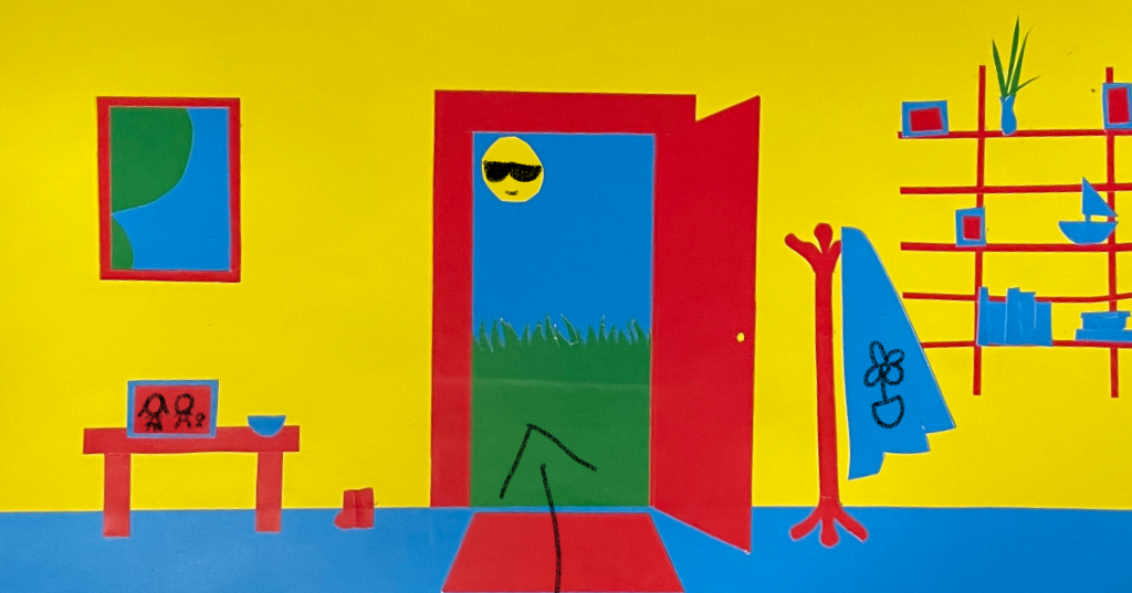 A front door constructed out of primary colour papers.